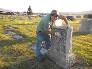 Kaleb Richardson cleaning a headstone.