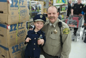 Lt. Tom Hodgson with the Utah County Sheriff’s Office from the 2014 Shop With A Cop event. Tom is a member of the Shop With A Cop Committee and was one of the original officers that implemented the program 26 years ago.
