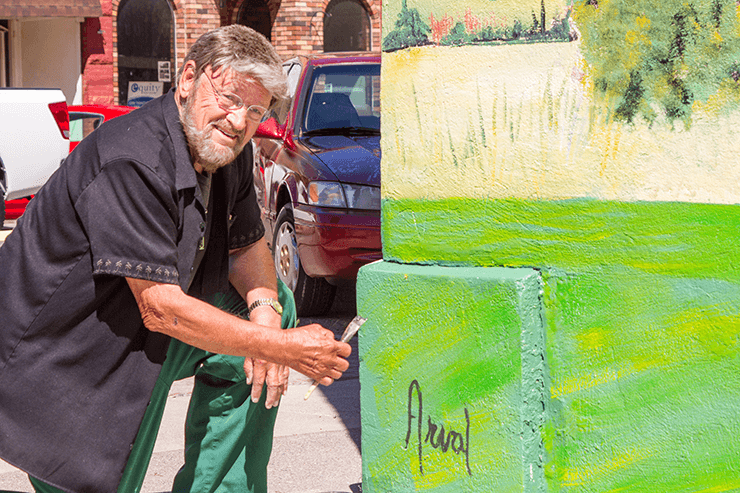 Mark Shipley signs the Mural at The Photo Shop in Payson. Photo by Ed Helmick