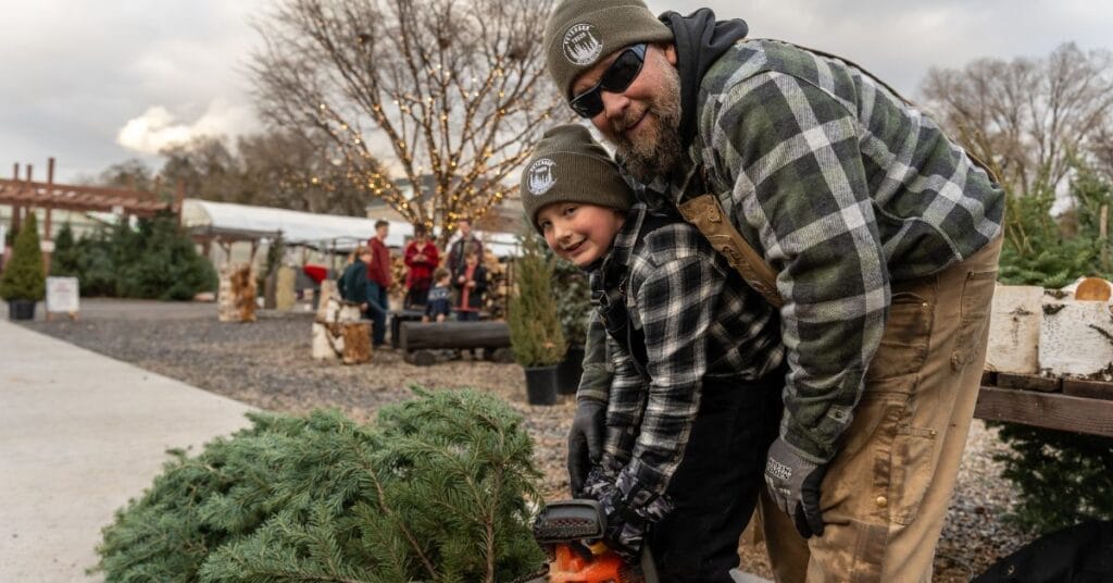 Derek with his son Steel cutting a Christmas Tree at Peterson Trees.