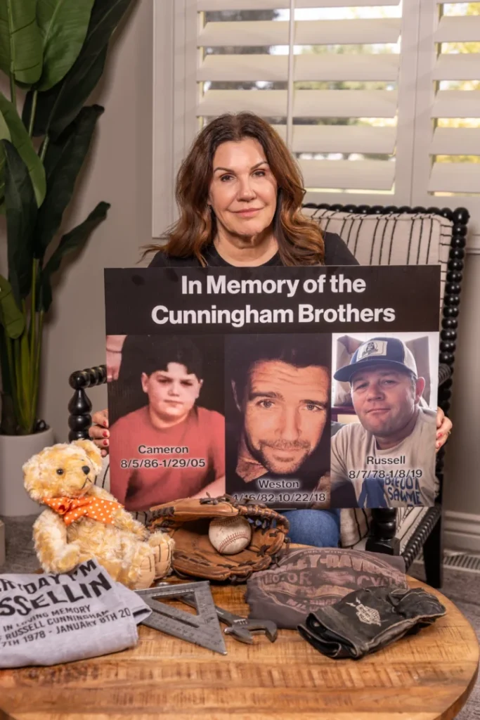 Cherri Gressman holding a photo of her sons: (Left to right) Cameron Cunningham, Weston Cunningham, Russell Cunningham.